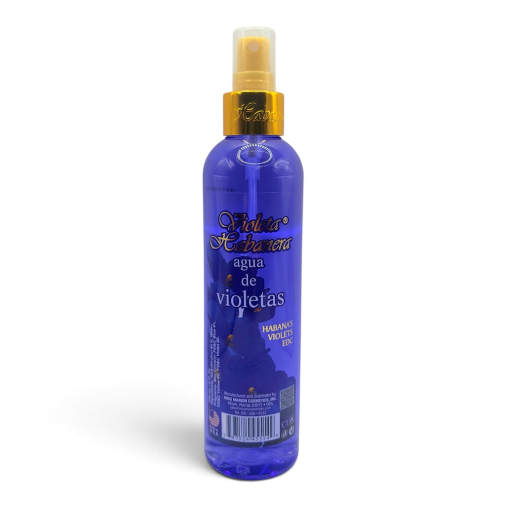 A bottle of Violeta Habanera Agua de Violetas spray, featuring a translucent blue bottle with a gold collar and a clear spray nozzle, set against a plain white background.